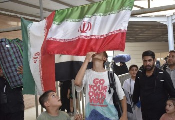 بوسه زائران کربلا بر پرچم ایران در مهران